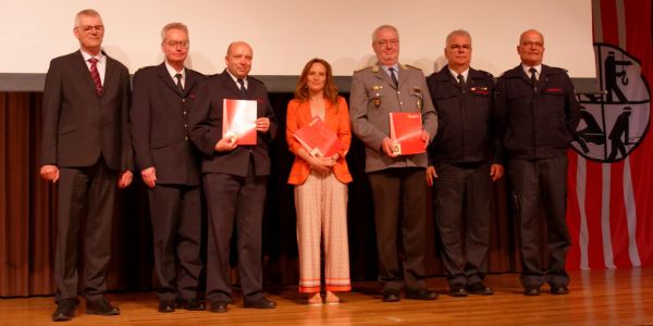Hauptmann Dirk Otte, Daniela Hoffmann und Christoph Schöneborn bekommen die Ehrennadel in Gold des Kreisfeuerwehrverbandes des Rhein-Sieg-Kreises überreicht.